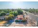Expansive aerial view of a quaint blue home with a red roof surrounded by lush greenery and a tranquil neighborhood at 140 W University Dr, Mesa, AZ 85201