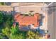 A bird's eye view of a cozy blue home with a red roof surrounded by lush green trees at 140 W University Dr, Mesa, AZ 85201