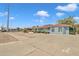 Low angle view of a single-story home with a blue brick facade, xeriscaping and paved driveway under a clear blue sky at 140 W University Dr, Mesa, AZ 85201