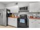 Well-lit kitchen features white cabinets, red countertops, and modern appliances at 140 W University Dr, Mesa, AZ 85201