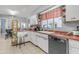 Charming kitchen featuring white cabinets, red countertops, and a stainless steel dishwasher at 140 W University Dr, Mesa, AZ 85201