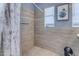 Accessible shower area with tiled walls, safety bars, shower curtain and bench at 140 W University Dr, Mesa, AZ 85201