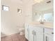 Bright bathroom with white cabinets, modern hardware, large mirror, and tiled floors with natural lighting at 1541 W Lynne Ln, Phoenix, AZ 85041