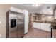 Bright kitchen boasts stainless fridge, white cabinets, and a view to the adjoining living space at 1541 W Lynne Ln, Phoenix, AZ 85041