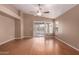 An open concept living room features hardwood floors, a ceiling fan, and sliding glass doors leading to the backyard at 1541 W Lynne Ln, Phoenix, AZ 85041