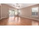 An open concept living room features hardwood floors, a ceiling fan, and sliding glass doors leading to the backyard at 1541 W Lynne Ln, Phoenix, AZ 85041