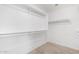 A large walk-in closet featuring wood flooring and white walls with multiple levels of shelving and hanging rods at 1541 W Lynne Ln, Phoenix, AZ 85041