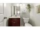 Bright bathroom features a vanity with a cherry wood cabinet, a toilet, and stylish wall decorations at 1645 W Baseline Rd # 2176, Mesa, AZ 85202