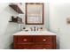 Bathroom featuring a dark wood vanity, shelving, and a framed mirror, creating a warm, inviting space at 1645 W Baseline Rd # 2176, Mesa, AZ 85202