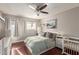 Cozy bedroom with hardwood floors, a ceiling fan, and a crib, offering a comfortable and Gathering-friendly space at 1645 W Baseline Rd # 2176, Mesa, AZ 85202