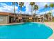 Inviting community pool surrounded by palm trees, lounge chairs, and well-maintained landscaping at 1645 W Baseline Rd # 2176, Mesa, AZ 85202