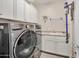 This laundry room features a gray washer and dryer, cabinets, and a utility sink at 16911 W Palm Ln, Goodyear, AZ 85395