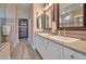 Elegant bathroom featuring dual sinks, large mirrors, and a walk-in closet area at 16911 W Palm Ln, Goodyear, AZ 85395