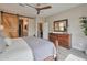 Charming main bedroom featuring a wooden dresser, barn door to bathroom, and ceiling fan at 16911 W Palm Ln, Goodyear, AZ 85395