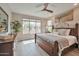 Comfortable main bedroom showcasing a large window, wooden bed frame, and neutral decor at 16911 W Palm Ln, Goodyear, AZ 85395