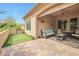 This covered patio features ample seating, ceiling fan, and a putting green just beyond the patio at 16911 W Palm Ln, Goodyear, AZ 85395