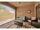 This patio features comfortable seating, a ceiling fan, and outdoor blinds at 16911 W Palm Ln, Goodyear, AZ 85395