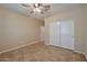Bedroom features neutral walls, tile floor, ceiling fan and a sliding door closet at 16955 W Cypress St, Goodyear, AZ 85395