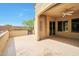 Covered outdoor patio featuring neutral flooring, desert landscaping, and a lovely gate detail at 16955 W Cypress St, Goodyear, AZ 85395