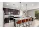 Bright kitchen with a granite island and seating, stainless steel appliances, and dark cabinets at 17160 N 9Th Pl, Phoenix, AZ 85022