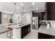 Modern kitchen with dark cabinets, granite countertops, and stainless steel appliances at 17160 N 9Th Pl, Phoenix, AZ 85022
