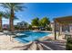 Community pool featuring lounge chairs, tables, and lush landscaping with shade for relaxation at 17160 N 9Th Pl, Phoenix, AZ 85022