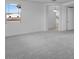 Neutral bedroom with carpeting, light paint, with view to other rooms and a window at 17827 W Medlock Dr, Litchfield Park, AZ 85340