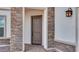 Inviting front entrance featuring a sturdy, earth-toned door framed by elegant stone accents and a stylish outdoor lantern at 17827 W Medlock Dr, Litchfield Park, AZ 85340