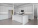 Clean, white kitchen with a center island, stainless steel appliances, and plenty of storage and counter space at 17827 W Medlock Dr, Litchfield Park, AZ 85340