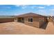Exterior rear view of a single-story home featuring a covered patio and spacious dirt lot at 17841 W Windsor Blvd, Litchfield Park, AZ 85340