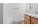 Bright bathroom featuring a light wood vanity, modern fixtures, and tub and shower combo at 17841 W Windsor Blvd, Litchfield Park, AZ 85340