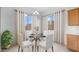 Cozy breakfast nook with a glass-top table, four chairs, and bright natural light from two windows at 17841 W Windsor Blvd, Litchfield Park, AZ 85340
