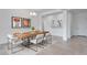 Dining room with a wood table set for six, a chandelier, and modern art on the white walls at 17841 W Windsor Blvd, Litchfield Park, AZ 85340