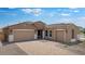 Charming home with a three-car garage and a brick paved driveway and walkway at 17841 W Windsor Blvd, Litchfield Park, AZ 85340