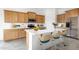 Bright kitchen with wood cabinets, stainless steel appliances, and a large white countertop island with seating at 17841 W Windsor Blvd, Litchfield Park, AZ 85340