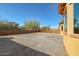 View of the large, dirt backyard with a low block wall at 18107 W Thunderhill Pl, Goodyear, AZ 85338