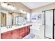 Bathroom featuring double sinks, a shower, a soaking tub, and a vanity with wood cabinets at 18107 W Thunderhill Pl, Goodyear, AZ 85338