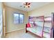 A small bedroom featuring bunk beds, neutral paint, and a window with blinds at 18107 W Thunderhill Pl, Goodyear, AZ 85338