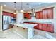 Stylish kitchen boasting stainless steel appliances, a center island, granite counters, and ample cabinet space at 18107 W Thunderhill Pl, Goodyear, AZ 85338