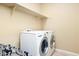 Laundry room featuring a washer, a dryer, and a shelf for storage at 18107 W Thunderhill Pl, Goodyear, AZ 85338