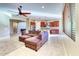 Open-concept living room showcasing tile floors, ceiling fan, and seamless flow into the kitchen at 18107 W Thunderhill Pl, Goodyear, AZ 85338