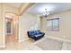 A staged living room showing an archway, a futon, and a chandelier at 18107 W Thunderhill Pl, Goodyear, AZ 85338