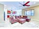 Spacious living room featuring tile floors, a ceiling fan, and a comfortable sectional sofa at 18107 W Thunderhill Pl, Goodyear, AZ 85338