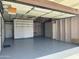 Spacious garage with painted floor, wooden framework and a storage area with shelves at 1822 E Roma Ave, Phoenix, AZ 85016