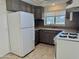 Traditional kitchen features ample cabinet space, white refrigerator, tile backsplash and granite countertops at 1822 E Roma Ave, Phoenix, AZ 85016