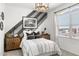 Stylish bedroom with a modern light fixture, gray striped accent wall, and natural light at 18353 W Gray Fox Trl, Wittmann, AZ 85361