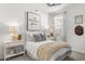 Cozy bedroom with a decorative wall hanging, two bedside tables, and a bright window at 18353 W Gray Fox Trl, Wittmann, AZ 85361