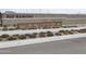 Rio Rancho Community entrance with landscaping and flowers at 18353 W Gray Fox Trl, Wittmann, AZ 85361