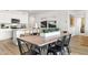 Open dining area with seating, blending into a modern kitchen featuring stainless steel appliances and neutral decor at 18353 W Gray Fox Trl, Wittmann, AZ 85361