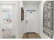 Inviting hallway featuring a white door, wooden floors, and a view into a bedroom at 18353 W Gray Fox Trl, Wittmann, AZ 85361